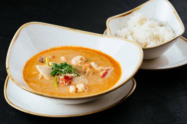 Asyalı Tom Yam çorbası ve siyah bir pilav.