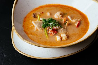 Asyalı Tom Yam çorbası ve siyah bir pilav.