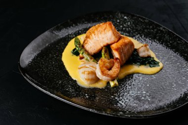 Siyah arka planda ızgara somon ve karides.