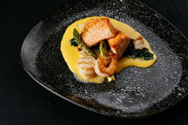 Siyah arka planda ızgara somon ve karides.