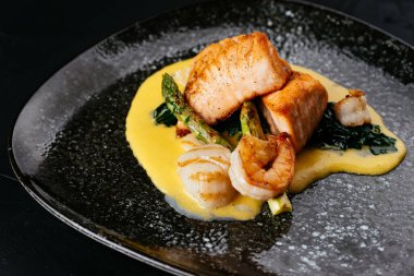 Siyah arka planda ızgara somon ve karides.