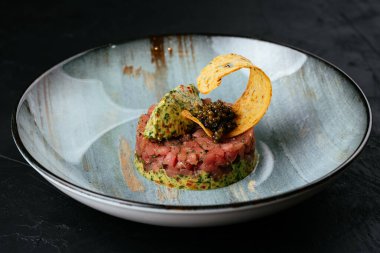 Siyah arka planda taze mermer etli tartar.