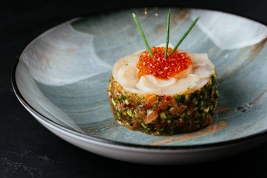 Siyah arka planda kırmızı havyarlı taze somon tartar.