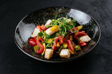 Siyah arka planda karides, sebze ve yengeç etli salata.