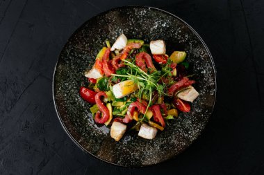 Siyah arka planda karides, sebze ve yengeç etli salata.