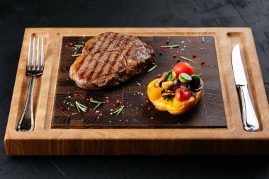 Sebzeli biftek ve siyah arka planda sos.