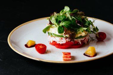 Sebzeli salata ve siyah arka planda yengeç eti.