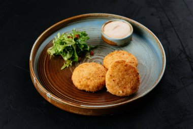 Siyah arka planda soslu ızgara somon pirzolası.