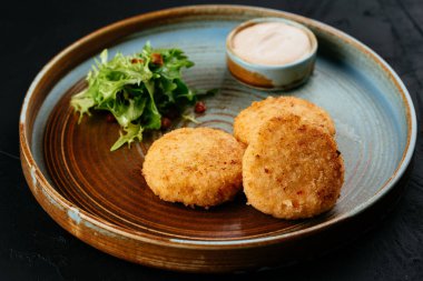 Siyah arka planda soslu ızgara somon pirzolası.