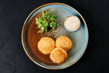 Siyah arka planda soslu ızgara somon pirzolası.