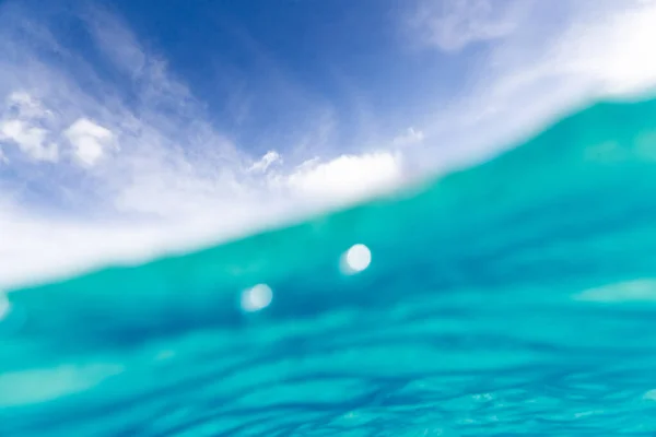 波浪和阳光下蓝色海水的模糊背景 — 图库照片