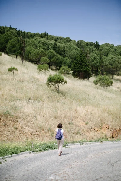 Ένα Νεαρό Κορίτσι Καπέλο Και Ένα Σακίδιο Περπατάει Στο Δρόμο — Φωτογραφία Αρχείου