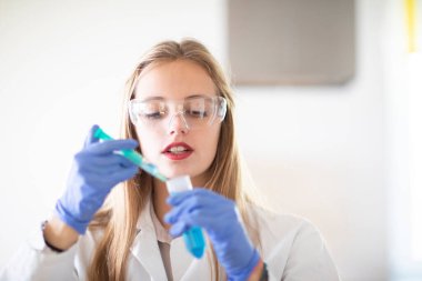 Beautiful young woman is working on the laboratory