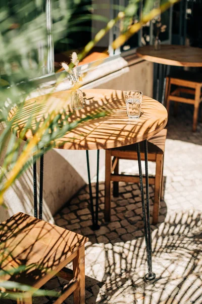 阳光明媚的日子里 户外咖啡馆木桌上的一杯冷水 — 图库照片