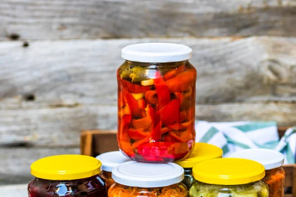 Jars with variety of canned vegetables and fruits, jars with zacusca. Preserved food concept in a rustic composition.