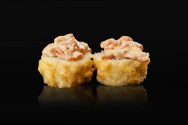 Japon suşisi siyah bir arkaplanda yuvarlanıyor.