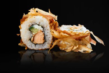 Japon suşisi siyah bir arkaplanda yuvarlanıyor.