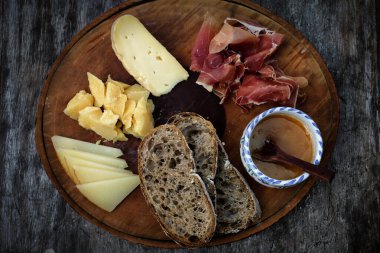 Tahta masada et ve sebzeli peynir ve ekmek.