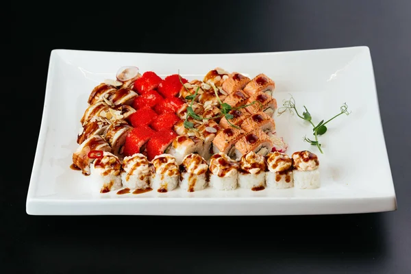 Set Sushi Japonés Sobre Plato Blanco Fondo Negro — Foto de Stock