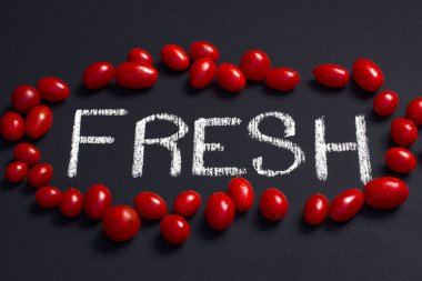 red vibrant cherry tomatoes surrounding the word fresh