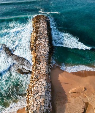 Aerial view from a stone jetty. Stone wave breaker blocks to protect t clipart