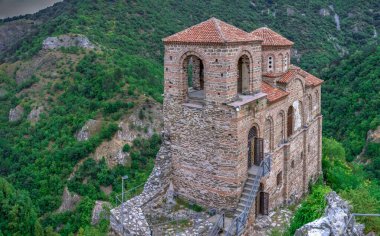 Asenovgrad, Bulgaristan 24.07.2019. Asens Kalesi 'ndeki Kutsal Meryem Ana Kilisesi bulutlu bir yaz gününde Bulgar Rodop dağlarını kuşatmıştı.