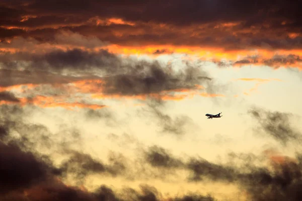 Ett Kommersiellt Flygplan Sänker Sig Genom Molnen Vid Solnedgången — Stockfoto