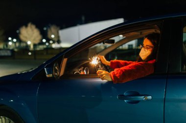 Geceleri arabanın içinde maytaplı bir kadın.