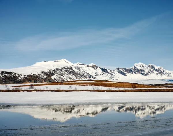 Majestátní Zasněžený Hřeben Hor Odrážející Klidné Vodě Jezera Pod Modrou — Stock fotografie