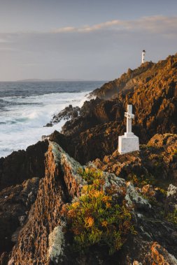 Deniz feneri gün batımında kıyı şeridinde