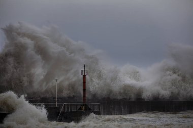 Büyük dalga bir rıhtıma sıçrıyor