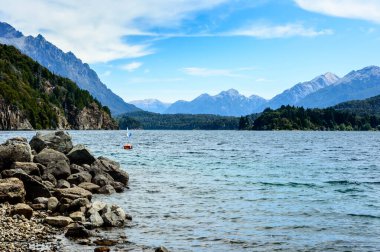 Bariloche Gölü 'nün sularında şamandıralı kayalık plajlar..