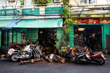 Man Sits in Automotive Repair Shop in Bangkok's Talat Noi Neighborhood