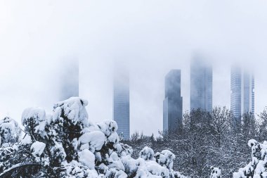 A view in winter of the Madrid four towers, view from a snowy park. clipart