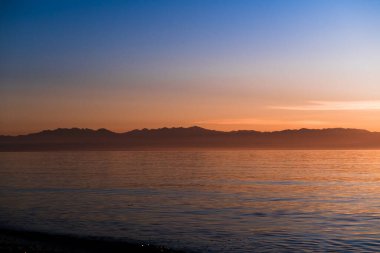 Sunset over the Olympic Mountains on the shores of Puget Sound clipart