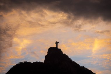 Güzel gün batımı manzaralı turuncu bulutlu İsa 'ya Corcovado Dağı tepesindeki Kurtarıcı Heykeli, Rio de Janeiro, Brezilya