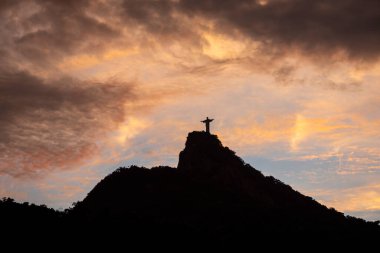 Güzel gün batımı manzaralı turuncu bulutlu İsa 'ya Corcovado Dağı tepesindeki Kurtarıcı Heykeli, Rio de Janeiro, Brezilya