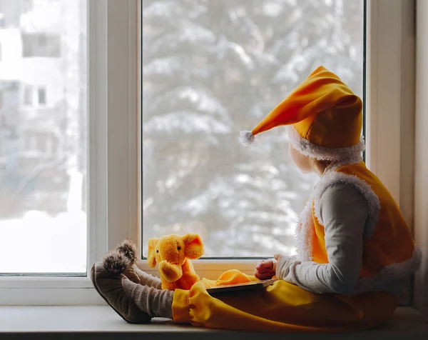 Malý Chlapec Žlutém Skřítčím Kostýmu Sedí Zimě Okně — Stock fotografie