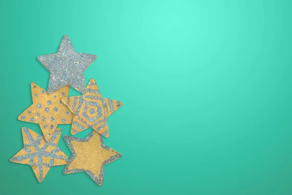 Five handmade stars lined with Christmas tree on a turquoise backgroun
