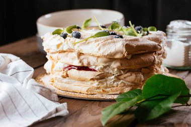 Karmaşık bir kompozisyonu, güzel manzarası, kurumuş meyveleri, hareketi, elleri olan karanlık bir arkaplanda Paskalya pastası.