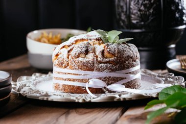 Karmaşık bir kompozisyonu, güzel manzarası, kurumuş meyveleri, hareketi, elleri olan karanlık bir arkaplanda Paskalya pastası.