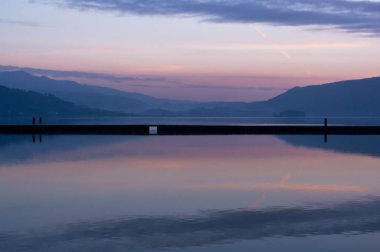 İnsanlar, tuz ve deniz üretiminde kullanılan yapay gölü ayıran bu güzel köprüde gün batımını seyrediyorlar. Bu bölge San Simn 'li Ensenada' ya ait. Rias Baixas, Pontevedra 'da bir koy.. 