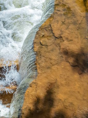 Keskin bir kayadan güzel küçük bir şelale.