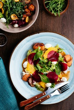 Somon, turp, kabak ve pancar salatasının en üst görüntüsü ahşap masada.