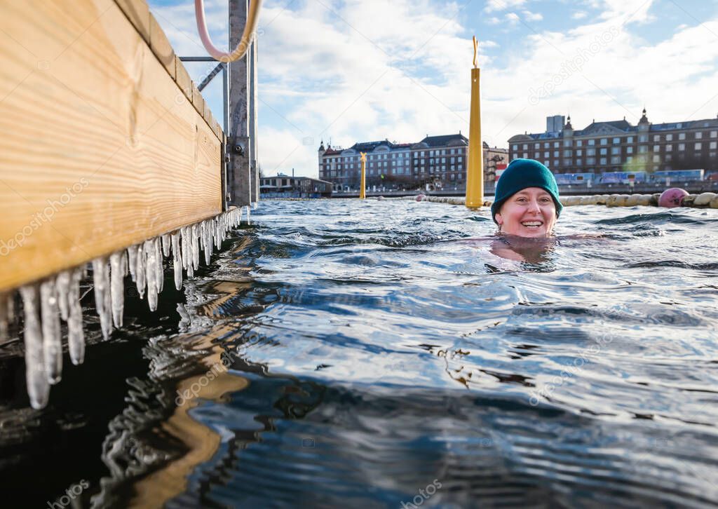 Smiling Woman Swimming By Icicles In Open Water Copenhagen, Denmark