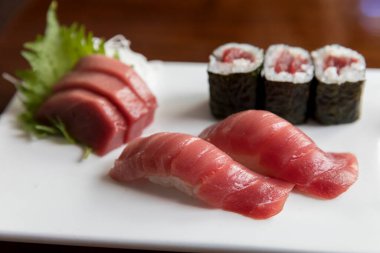 Ton balığı sashimi ve suşi beyaz tabakta.