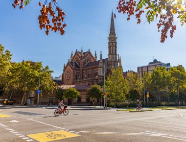 Barselona 'daki kilisenin önünde insanlar koşuyor ve bisikletçiler koşuyor.