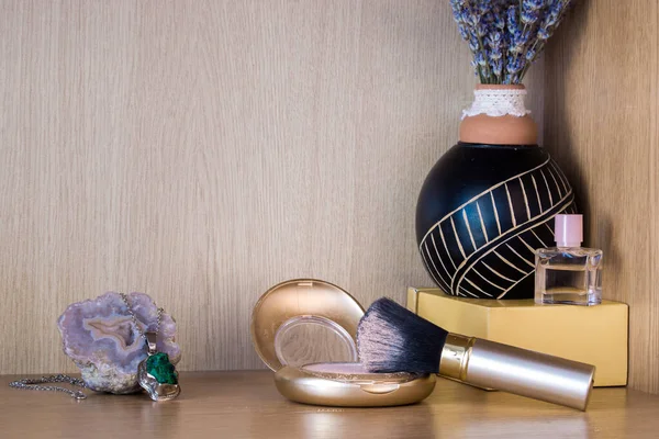 Beauty products with jewelry in the corner on a wooden shelf