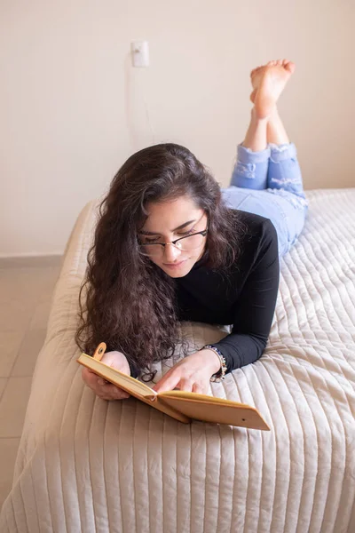 Νεαρή Γυναίκα Που Σπουδάζει Στο Κρεβάτι — Φωτογραφία Αρχείου