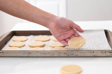 Kurabiye hamurunu fırın tepsisine koyan bir adam..